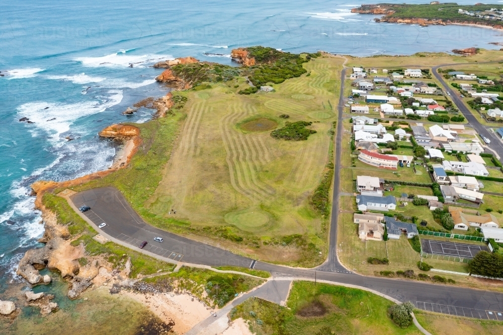 Aerial view of a golf course and carpark along side a rugged coastline - Australian Stock Image