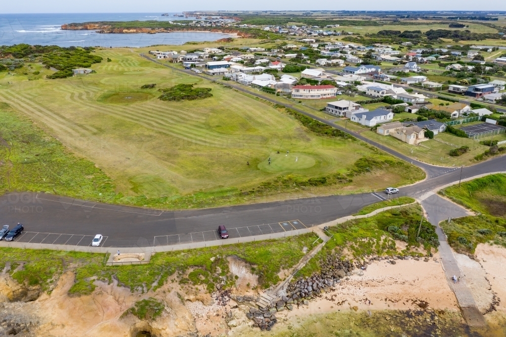 Aerial view of a golf course and carpark next to a coastal town - Australian Stock Image