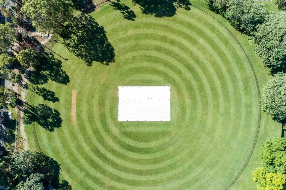 Aerial view of a grassy cricket oval with covers over the wicket. - Australian Stock Image