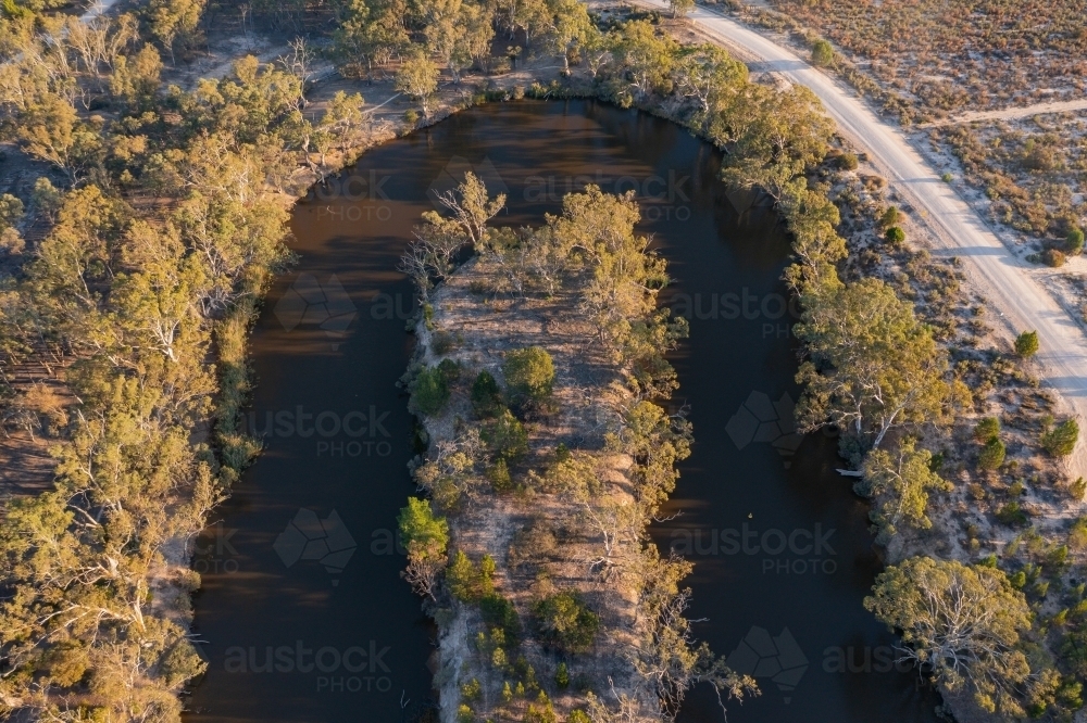 Aerial view of a hairpin bend in a murky river lined with gumtrees - Australian Stock Image