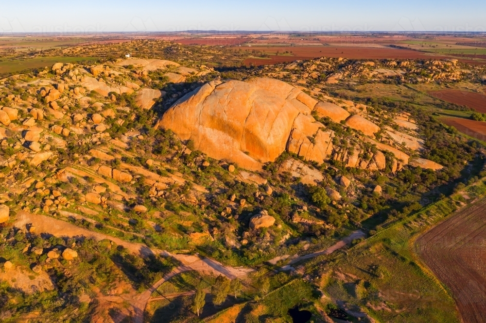 Image of Aerial view of a large granite mountain in late evening