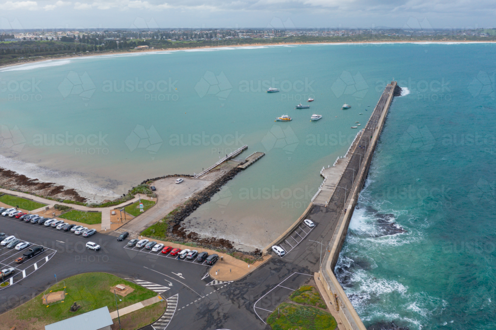 Aerial view of a long coastal breakwater on an ocean bay - Australian Stock Image