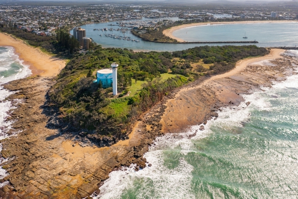 Aerial view of a modern lighthouse on a coastal clifftop next to a water supply tank : Austockphoto Aerial view of a modern lighthouse on a coastal clifftop next to a water supply tank - Australian Stock Image