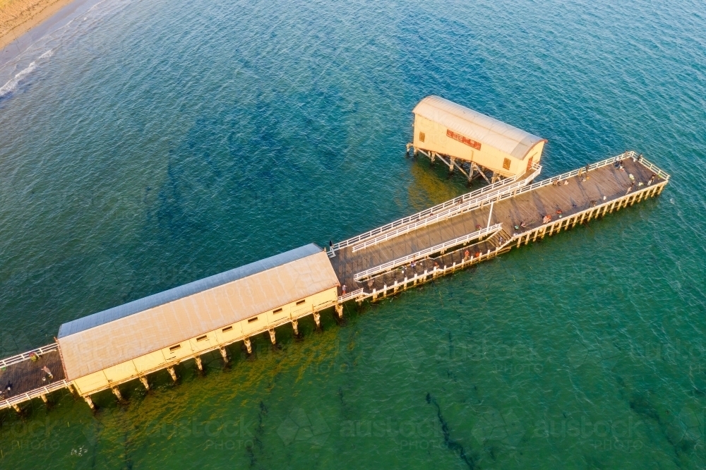 Aerial view of a narrow jetty out over the ocean - Australian Stock Image