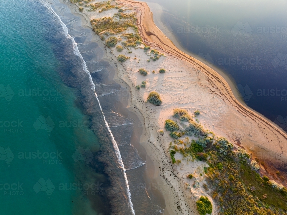 Aerial view of a narrow strip of beach with calm sea on both sides - Australian Stock Image