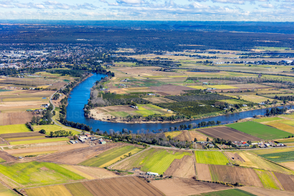 Aerial view of a patchwork farmland beside the meandering river - Australian Stock Image