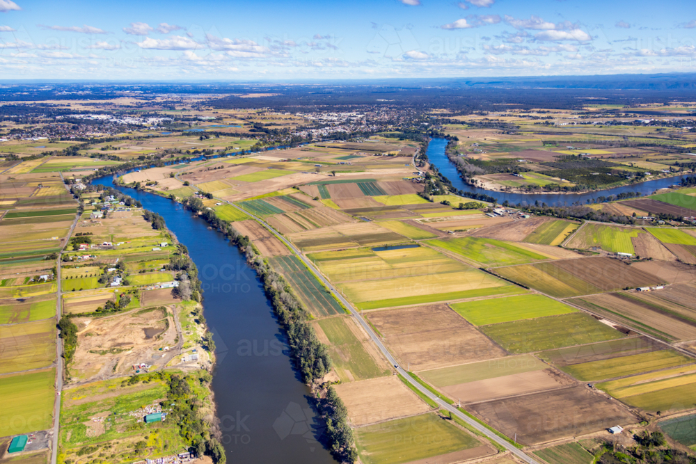 Aerial view of a patchwork farmland beside the meandering river - Australian Stock Image