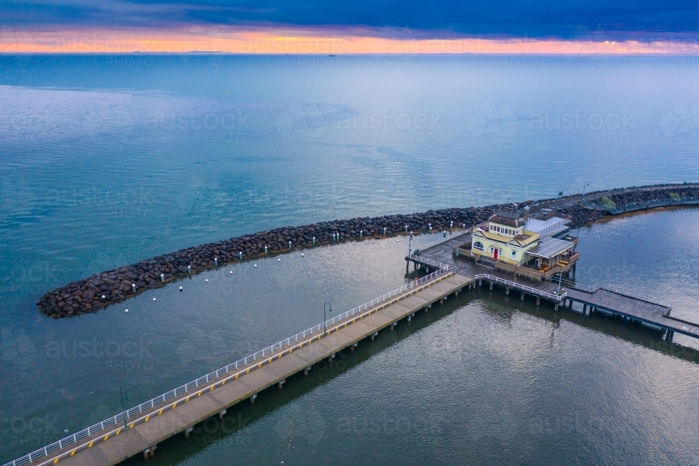 Aerial view of a pavilion on a jetty on a calm bay at sunset - Australian Stock Image