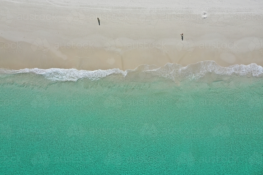 Aerial view of a Perth beach in summer, with the long shadows of people walking in the early morning - Australian Stock Image