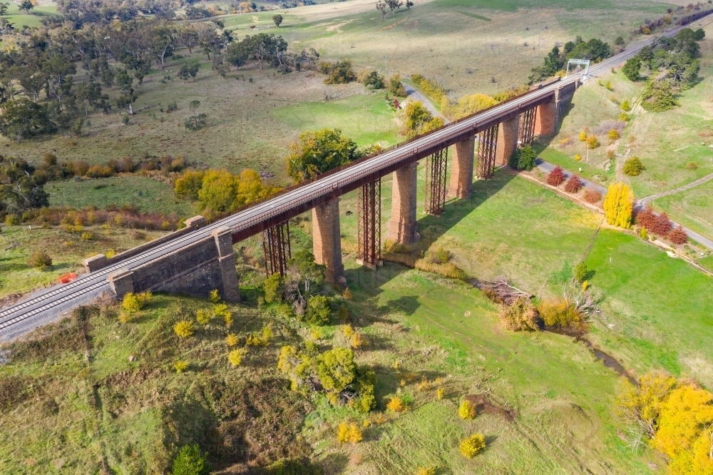 Image of Aerial view of a railway bridge over a valley with dotted with