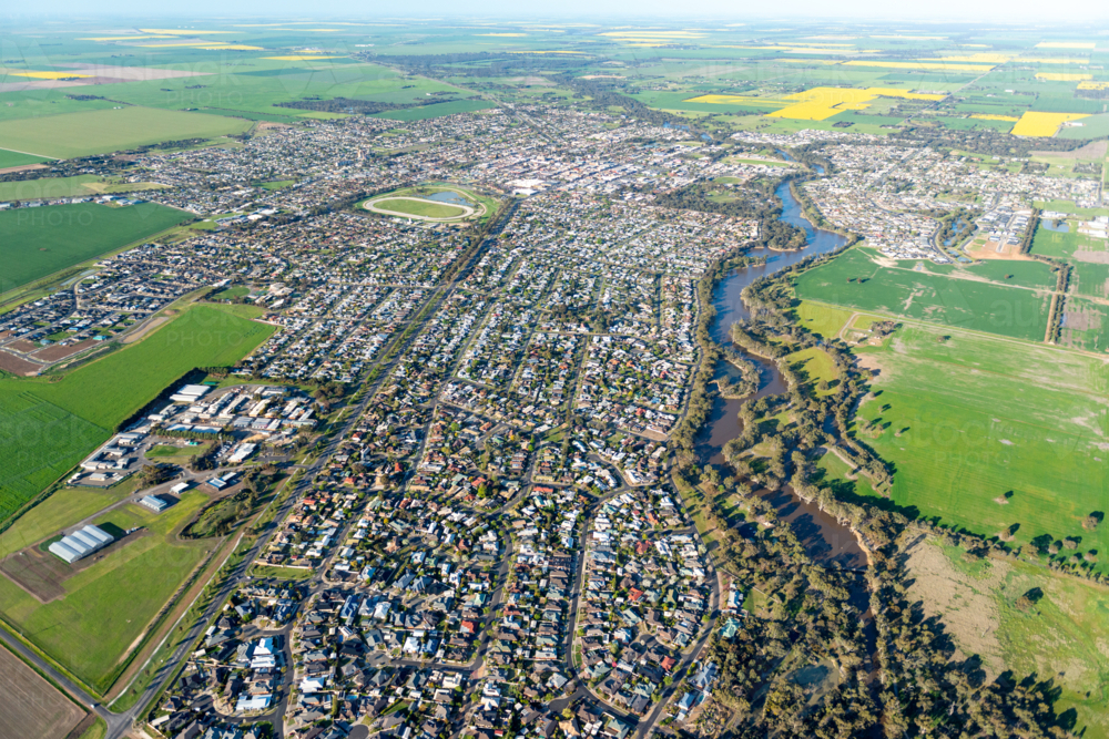 Aerial view of a regional city surrounded by green farmland - Australian Stock Image