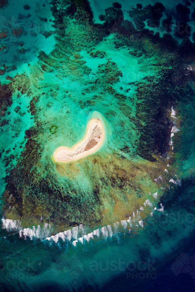 Aerial view of a remote sandy cay surrounded by coral reef and turquoise sea - Australian Stock Image