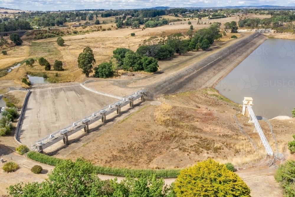 Aerial view of a reservoir and dam wall with a dry spillway. - Australian Stock Image