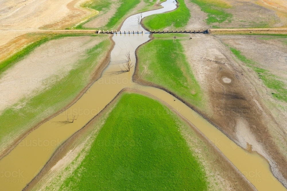Aerial view of a river running through the ruins of an old railway bridge - Australian Stock Image
