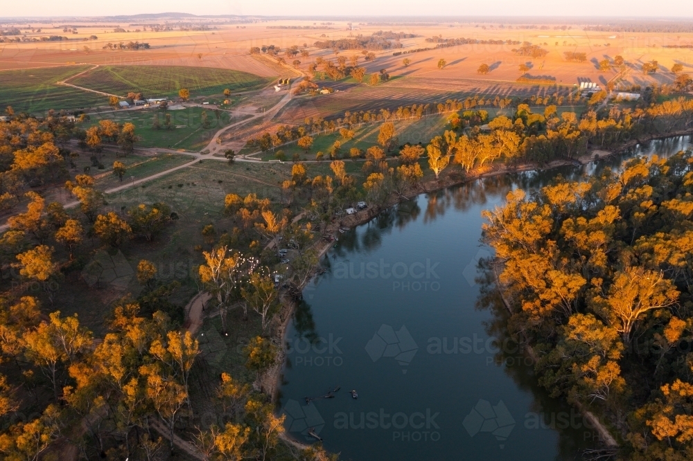 Aerial view of a river winding through a forest and farmland in late afternoon lighting - Australian Stock Image