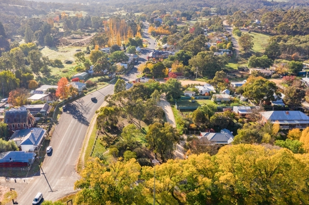 Aerial view of a road curving through a country town in Autumn - Australian Stock Image