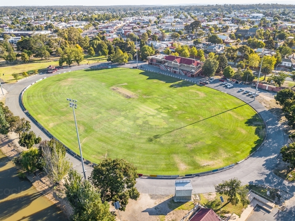 Image of Aerial view of a road surrounding a football oval and grandstand Austockphoto