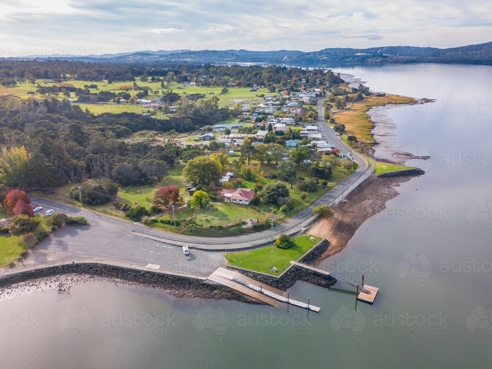 Aerial view of a road winding past a boat ramp on the banks of a river - Australian Stock Image