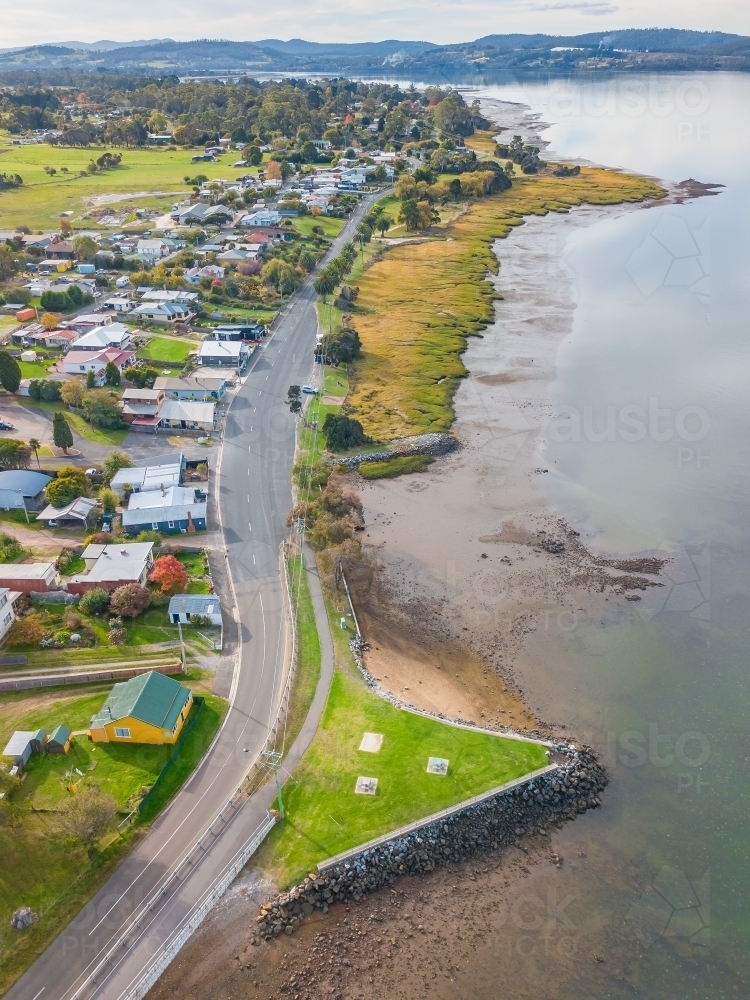 Aerial view of a road winding through a town on the banks of a river. - Australian Stock Image