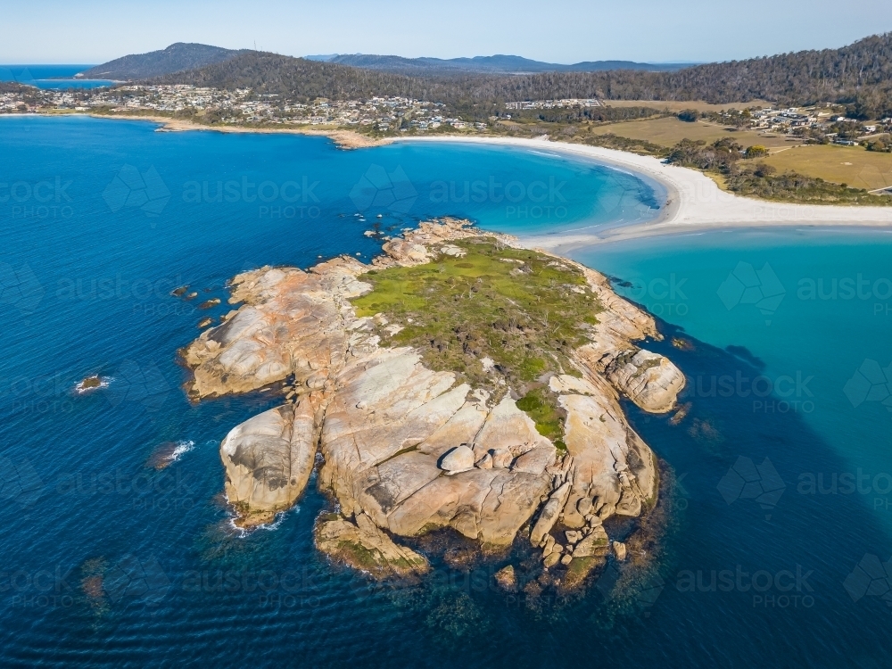 Aerial view of a rocky island off the coast of a sandy beach - Australian Stock Image