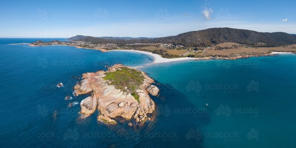 Aerial view of a rocky island off the coast of a sandy beach - Australian Stock Image