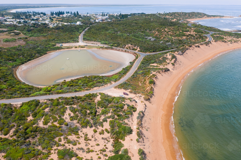 Aerial view of a salt lake circled by roads along a sandy coastline - Pool of Siloam - Australian Stock Image