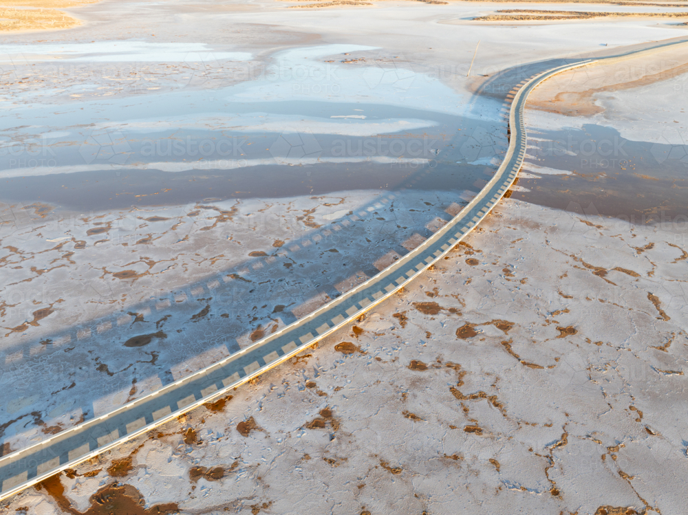 Aerial view of a salt lake with a pedestrian walkway running diagonally through the image - Australian Stock Image