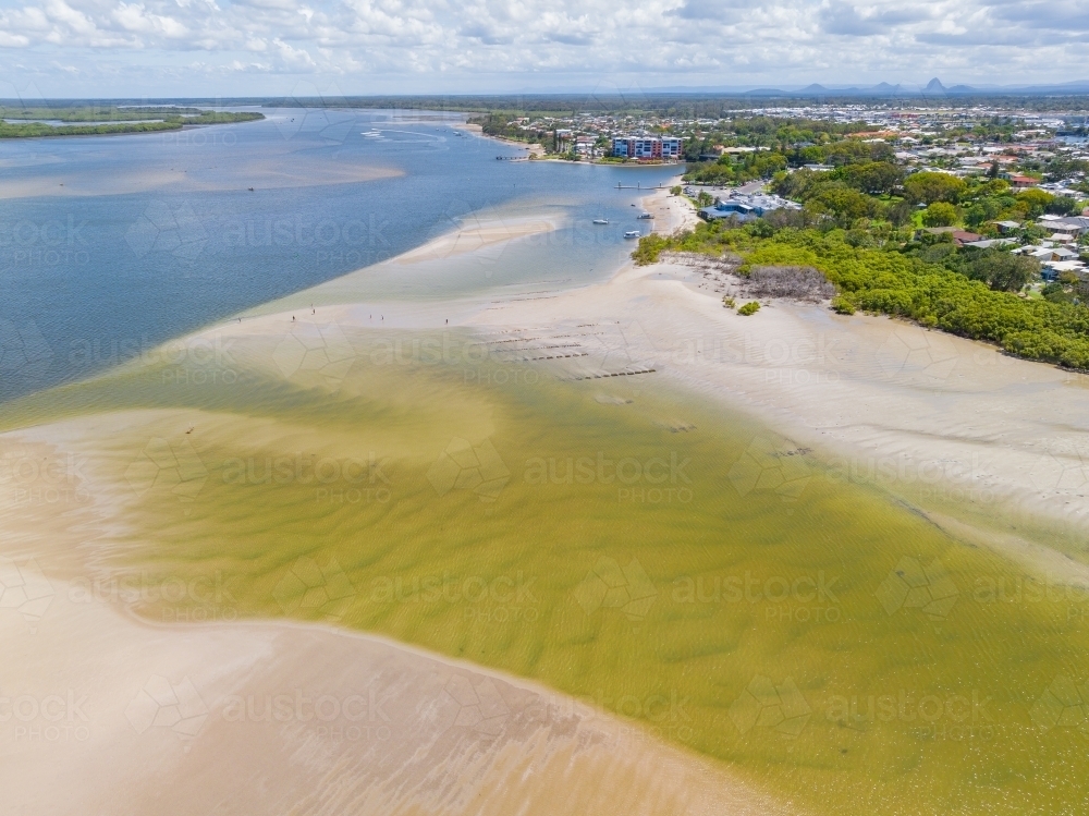 Image of Aerial view of a shallow inlet flowing out to sea over sand ...
