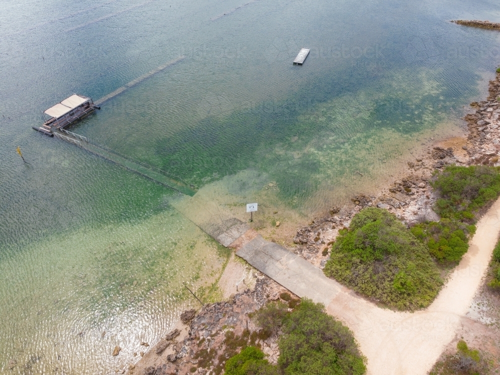 Image of Aerial view of a small boat ramp leading out to an oyster farm