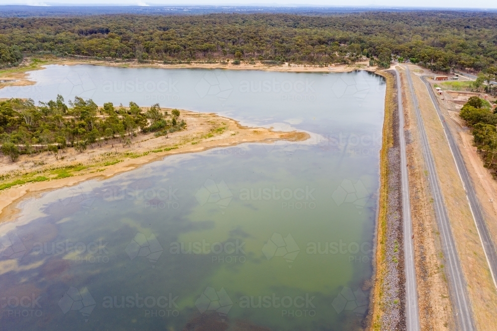 Aerial view of a small island in a reservoir and dam wall - Australian Stock Image