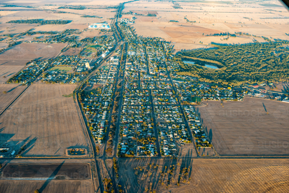 Aerial view of a small rural town showing grid streets surrounded by open agricultural farmland - Australian Stock Image