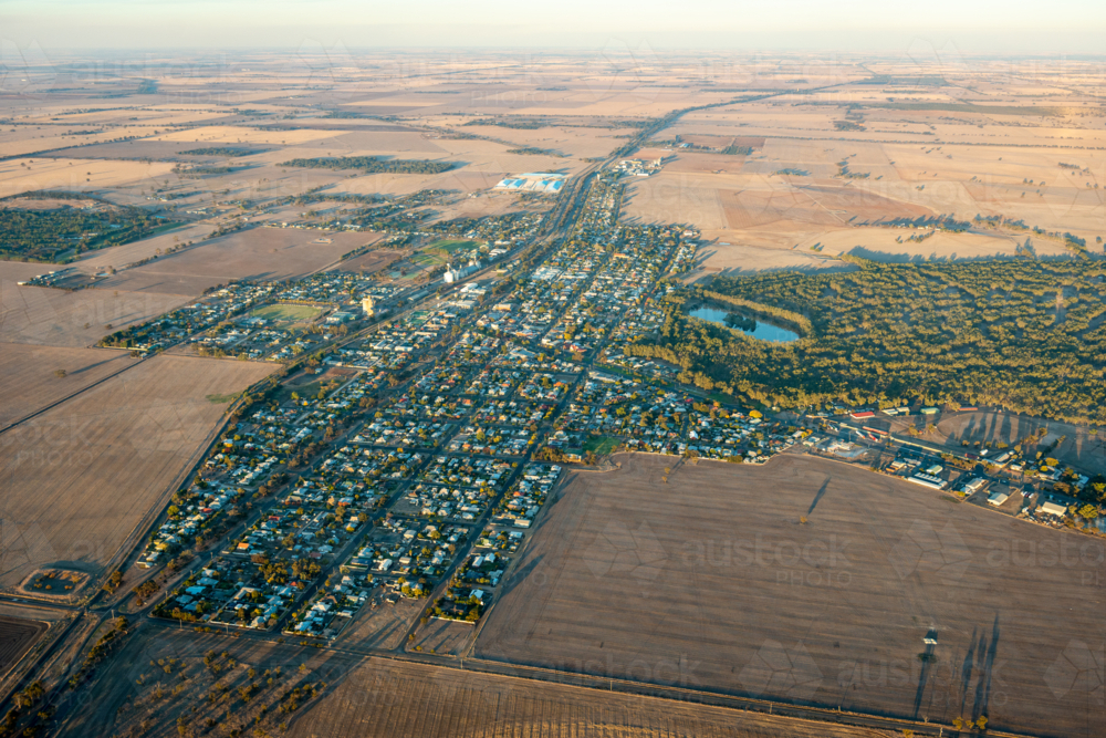 Aerial view of a small rural town showing grid streets surrounded by open agricultural farmland - Australian Stock Image