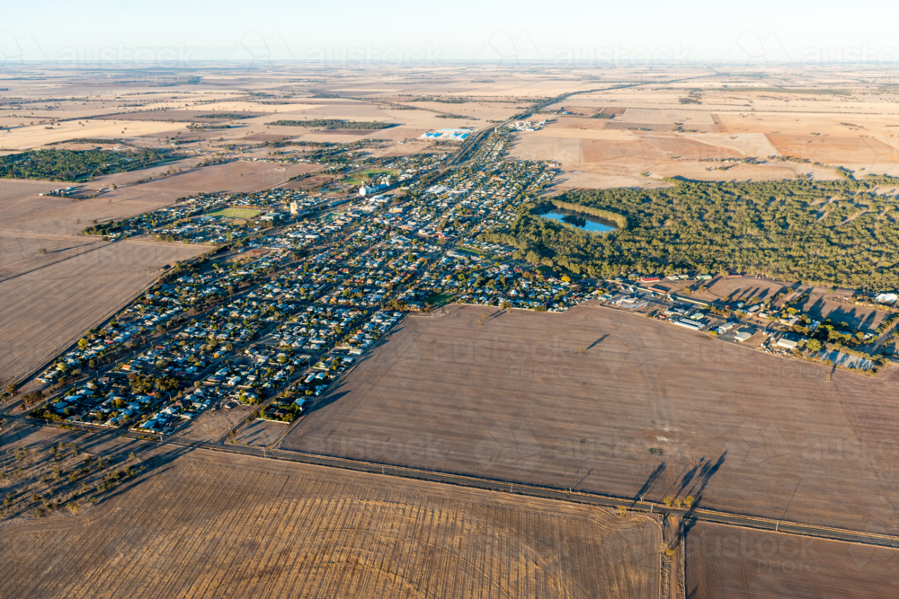 Aerial view of a small rural town showing grid streets surrounded by open agricultural farmland - Australian Stock Image