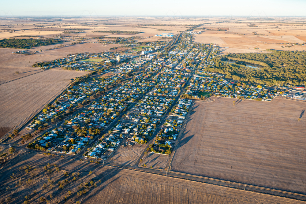 Aerial view of a small rural town showing grid streets surrounded by open agricultural farmland - Australian Stock Image
