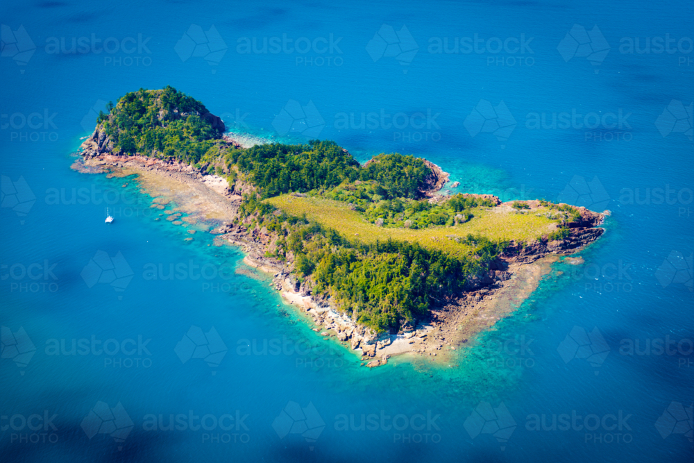 Aerial view of a small tropical island surrounded by turquoise water - Australian Stock Image