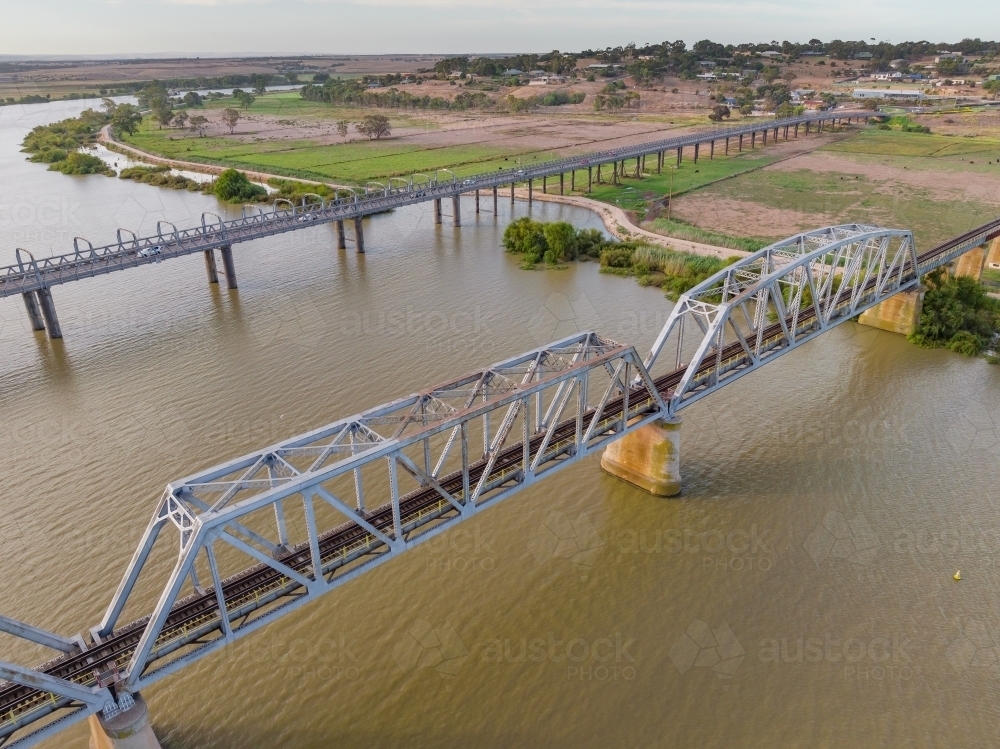 Aerial view of a steel bridge crossing a wide brown river - Australian Stock Image