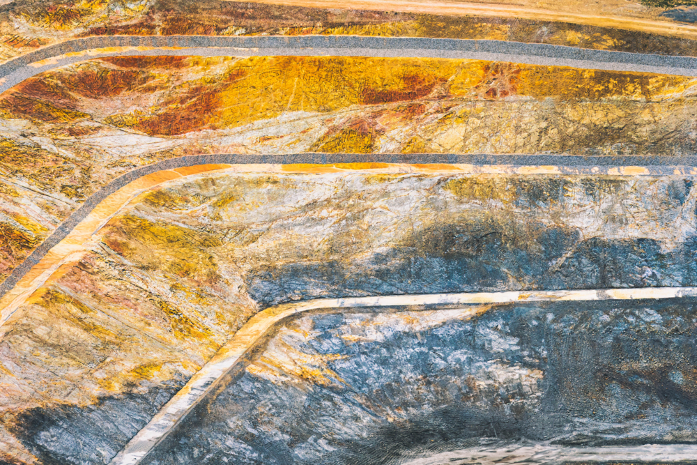 Aerial view of a terraced large open pit mine exposing earth layers - Australian Stock Image