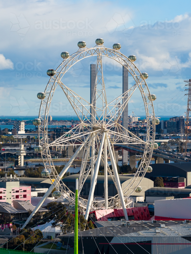 Aerial view of a tourist ferris wheel amongst city buildings at Docklands in Melbourne, Victoria - Australian Stock Image