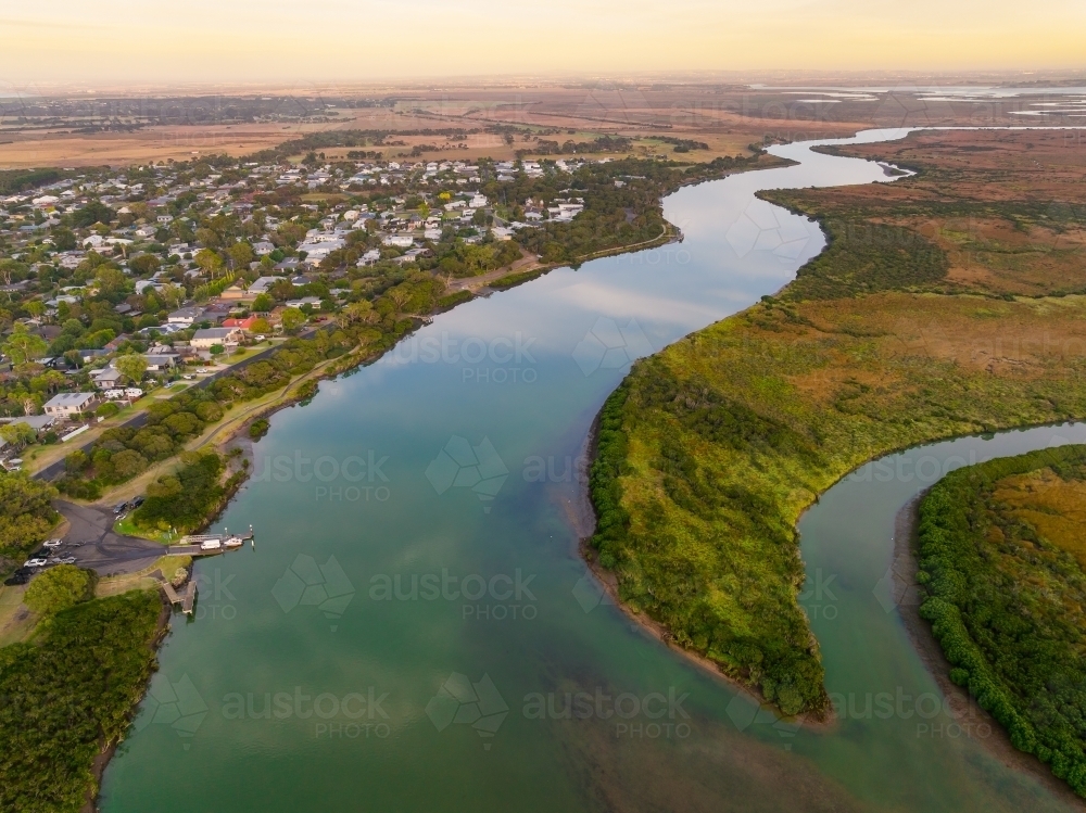 Image of Aerial, view of a town on the side of a large river winding ...