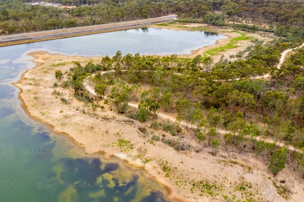 Aerial view of a walking track winding around the edges of reservoir - Australian Stock Image