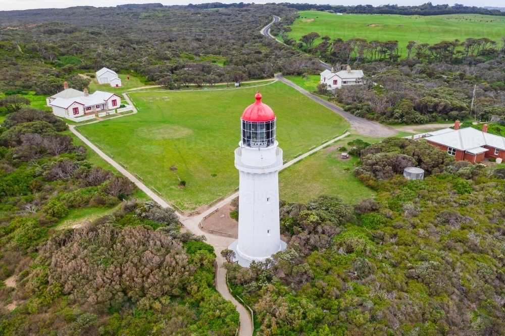 Aerial view of a white lighthouse with a red top and surrounding walking tracks - Australian Stock Image