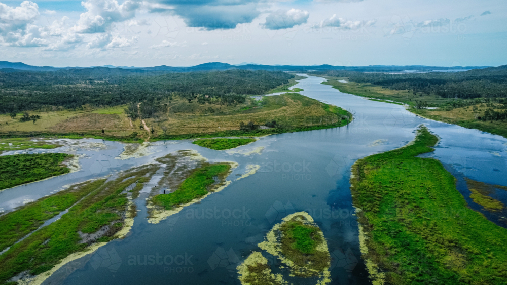 Aerial view of a winding river cutting through a lush, green landscape - Australian Stock Image