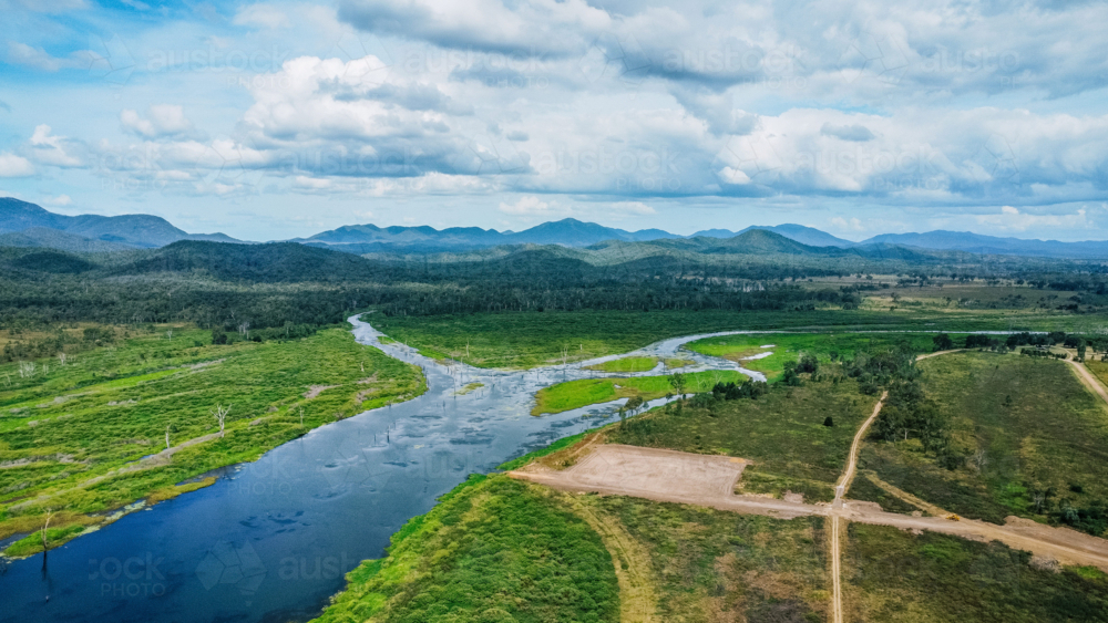 Aerial view of a winding river cutting through a lush, green landscape - Australian Stock Image
