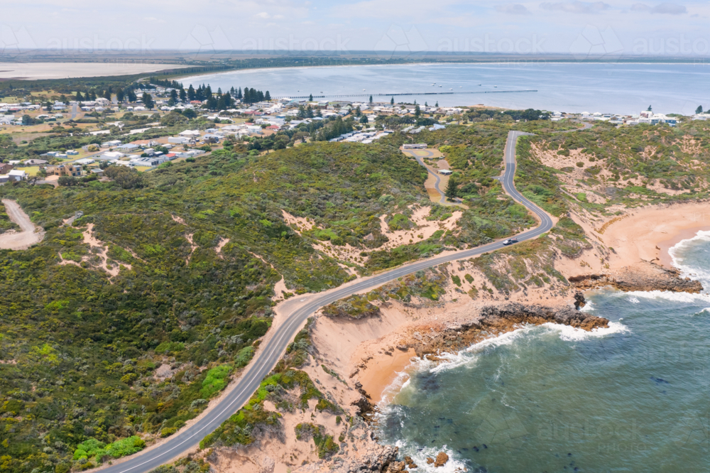 Image of Aerial view of a winding road between a town and a rugged ...