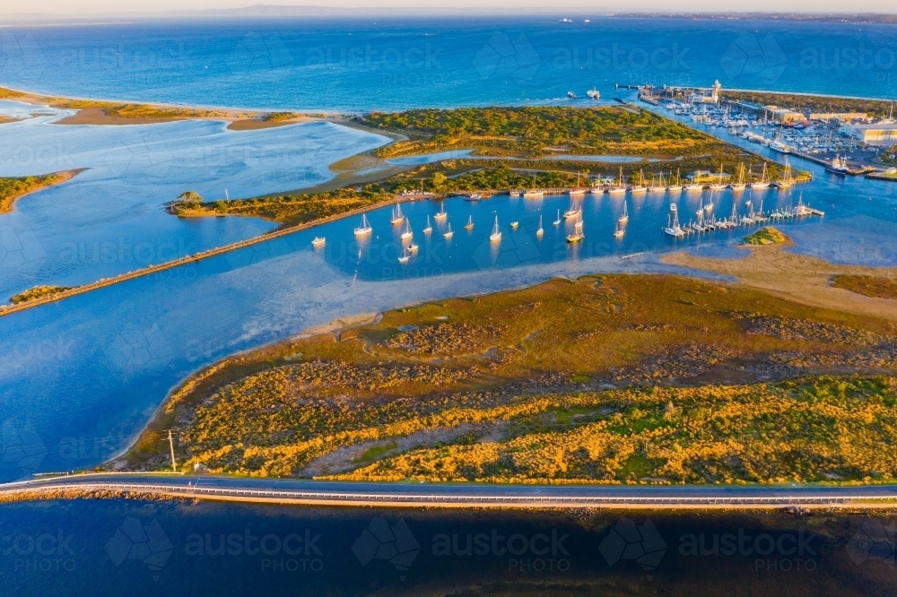 Image of Aerial view of a yacht club and marina between an island and a