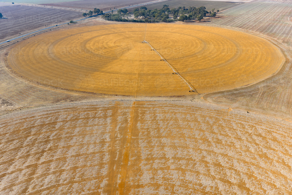 Aerial view of an irrigation sprinkler on a dry circular crop - Australian Stock Image
