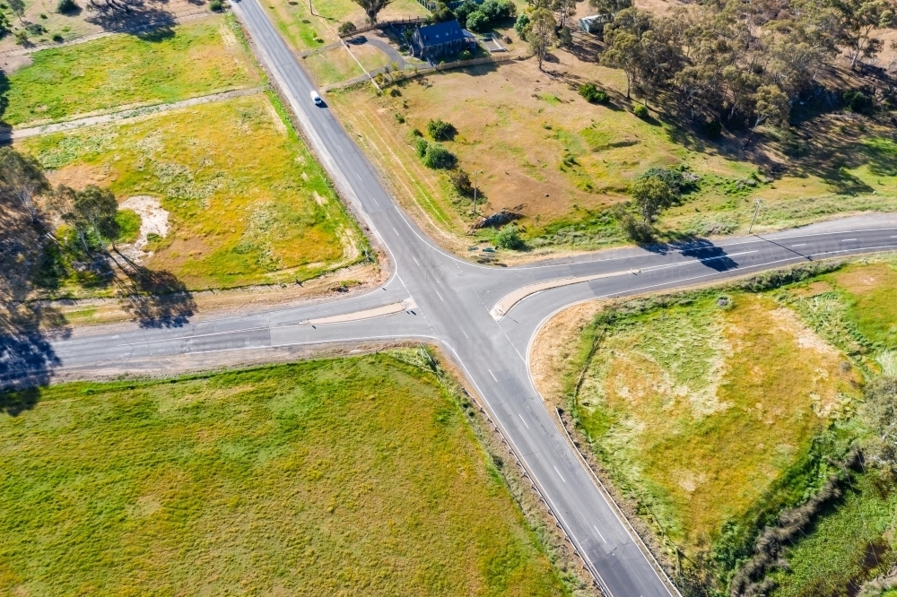 Aerial view of an open rural crossroads bordered by empty paddocks - Australian Stock Image