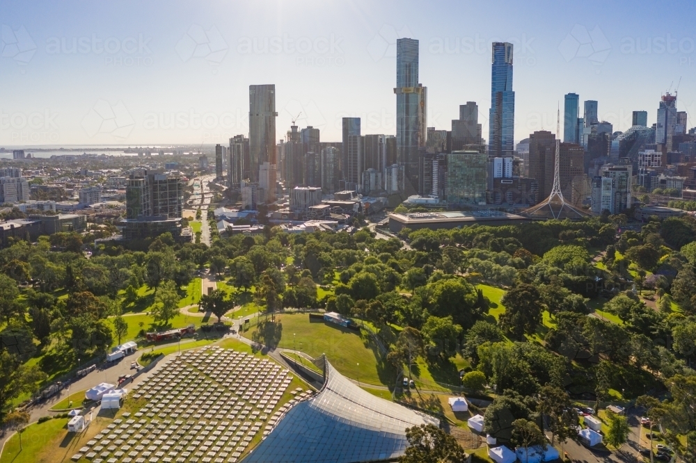 Aerial view of an outdoor auditorium in parkland in front of a city skyline - Australian Stock Image