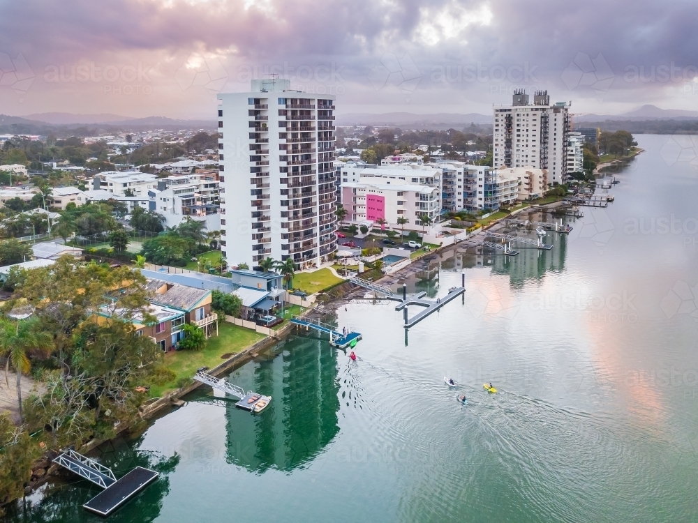 Aerial view of apartment buildings along the sides of the Maroochy River at sunset. - Australian Stock Image