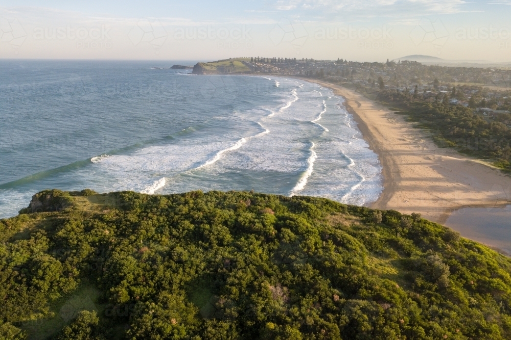 Aerial view of beach and coastal town at sunset - Australian Stock Image